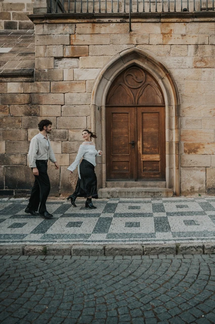 Prague couple photoshoot: couple stepping together across the patterned Kampa pavement. Couple stepping together across the patterned Kampa pavement during a couple photoshoot in Prague.