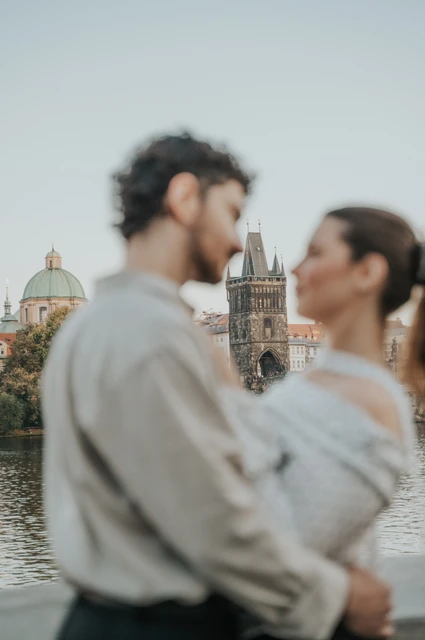 Prague couple photoshoot: soft-focus close portrait of the couple beside the Vltava. Soft-focus close portrait of the couple beside the Vltava during a couple photoshoot in Prague.