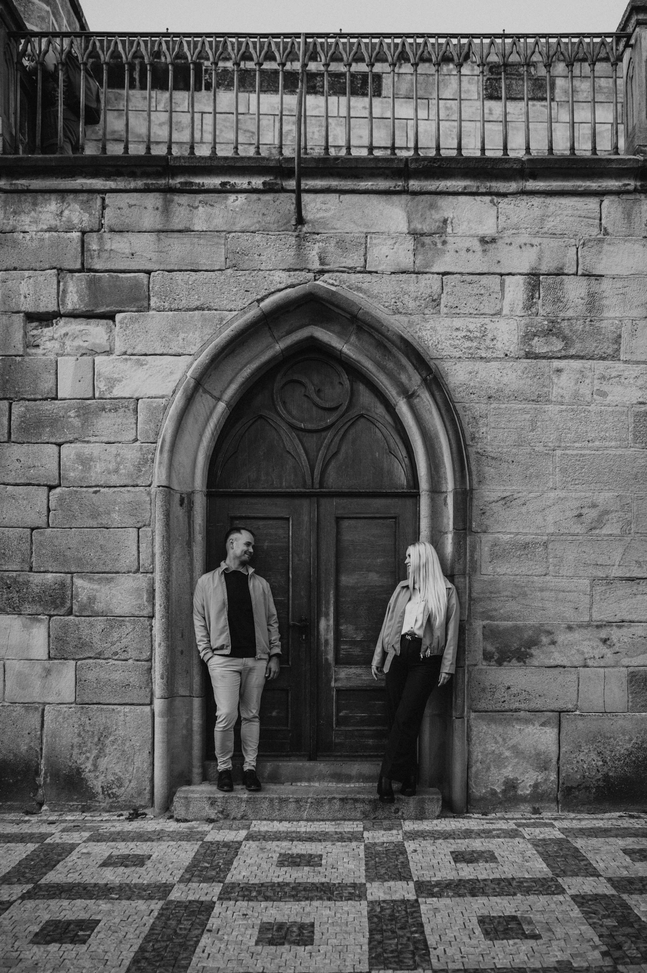 Black and white portrait beside the arched doorway during a couple photoshoot in Prague.