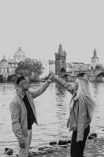 Prague couple photoshoot: black and white portrait of the couple dancing by the river. Black and white portrait of the couple dancing by the river during a couple photoshoot in Prague.