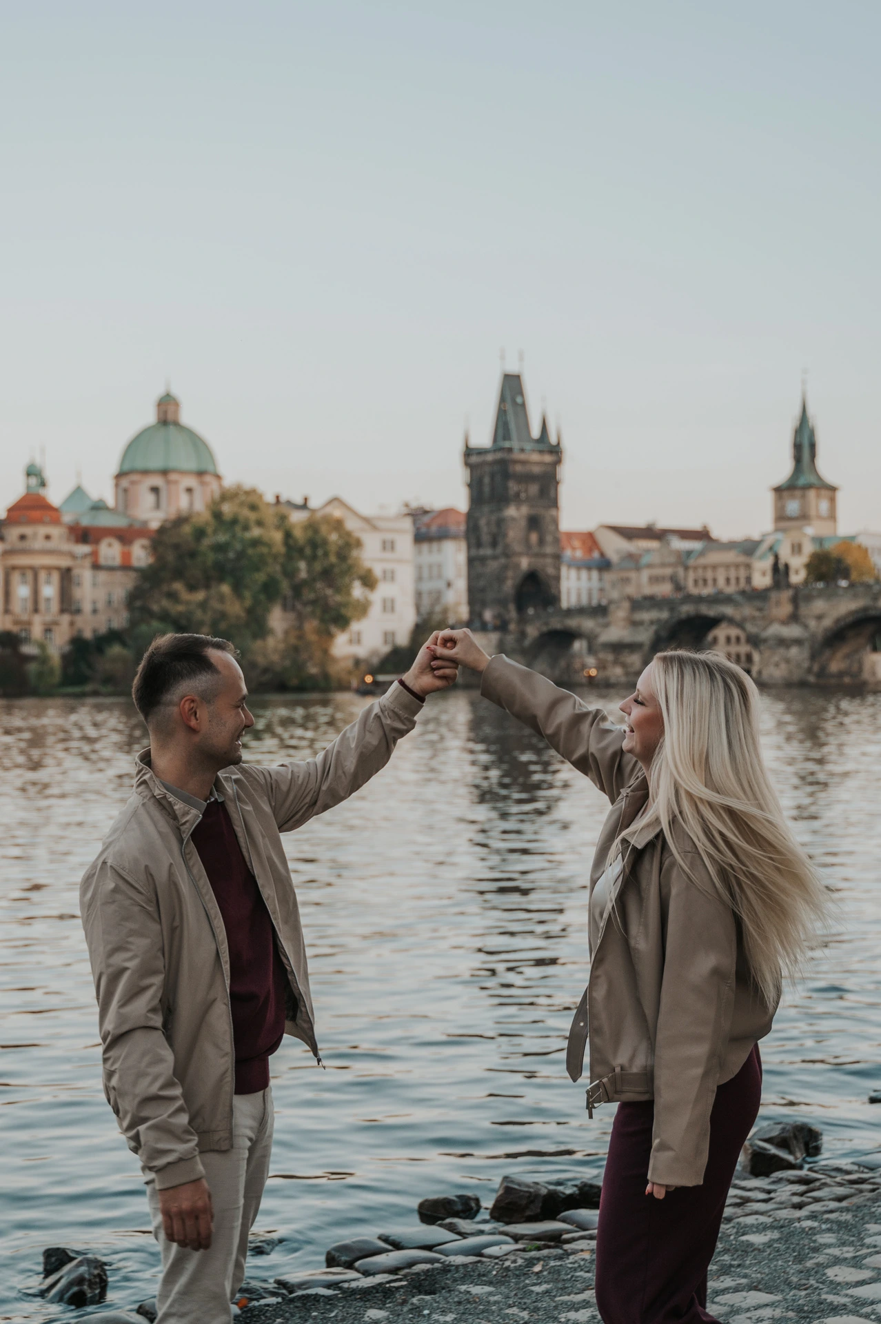 Close portrait of a twirl beside the Vltava during a couple photoshoot in Prague.