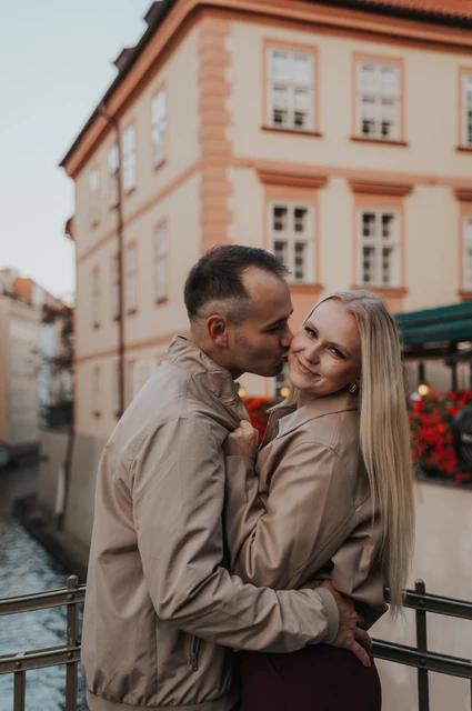 Prague couple photoshoot: close portrait of the couple smiling by the Kampa railings. Close portrait of the couple smiling by the Kampa railings during a couple photoshoot in Prague.