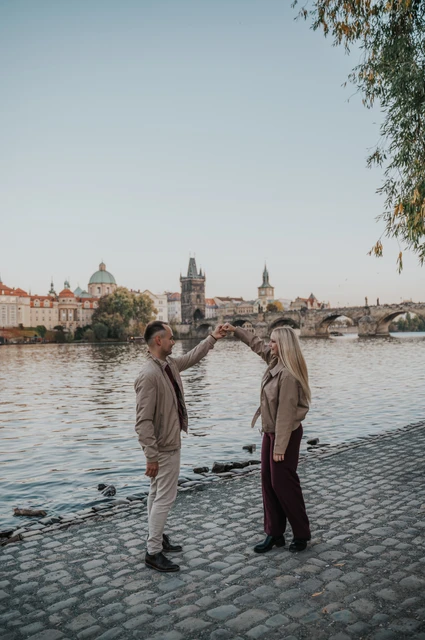 Prague couple photoshoot: couple dancing beneath the riverside willow. Couple dancing beneath the riverside willow during a couple photoshoot in Prague.