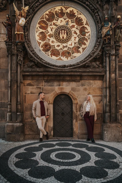 Prague couple photoshoot: couple standing beneath the Astronomical Clock. Couple standing beneath the Astronomical Clock during a couple photoshoot in Prague.
