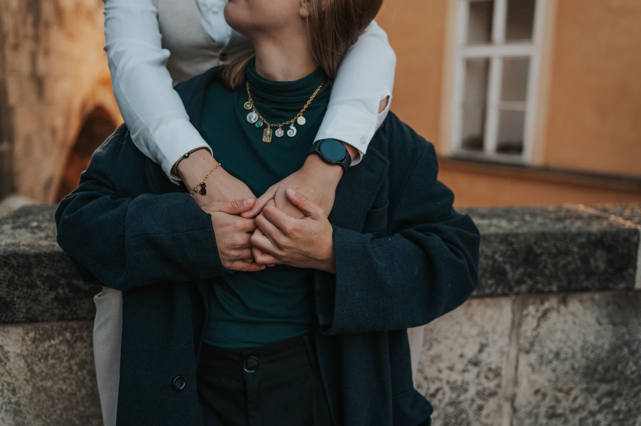 Prague couple photoshoot: close detail of the couple holding hands on the stone ledge. Close detail of the couple holding hands on the stone ledge during a couple photoshoot in Prague.