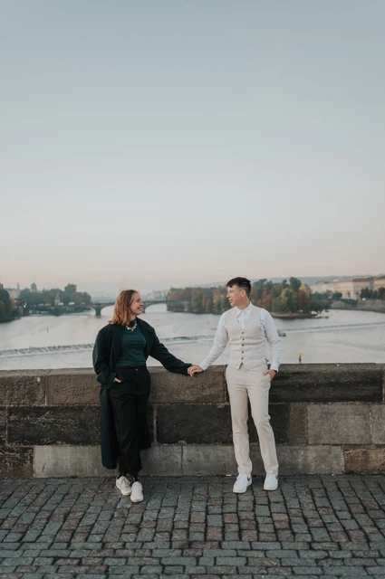 Prague couple photoshoot: couple holding hands beside the Vltava view. Couple holding hands beside the Vltava view during a couple photoshoot in Prague.