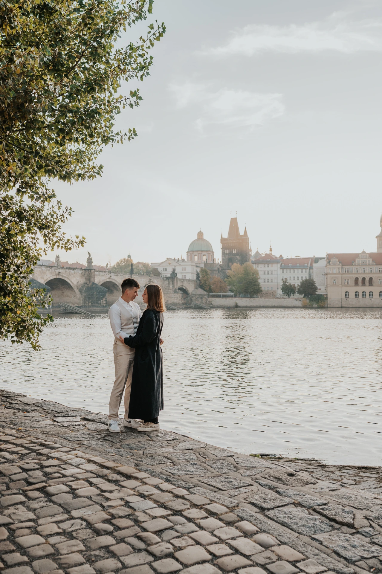 Couple kissing beside the Vltava in Kampa during a couple photoshoot in Prague.