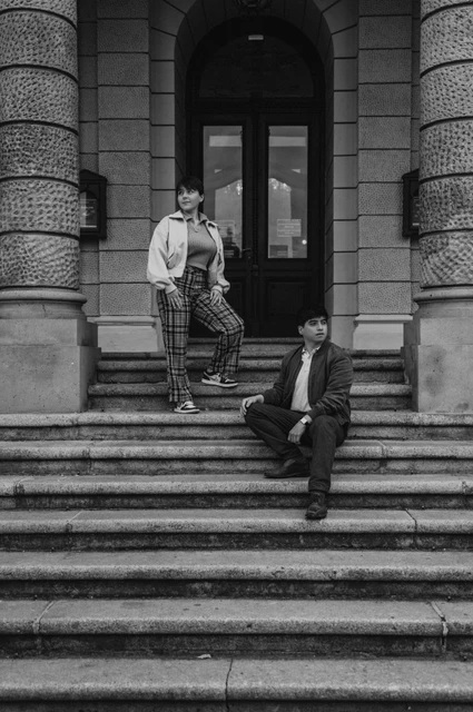 Prague couple photoshoot: black and white portrait of the couple on the opera steps. Black and white portrait of the couple on the opera steps during a couple photoshoot in Prague.