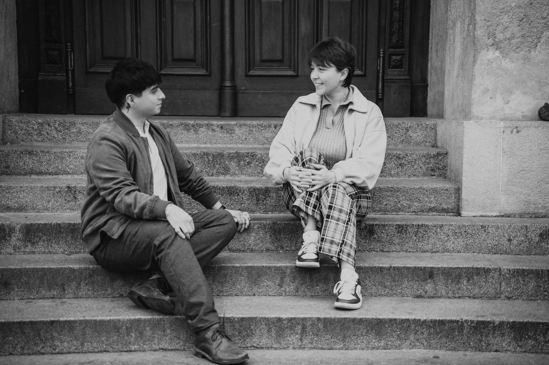 Black and white portrait of the couple on the steps during a couple photoshoot in Prague.