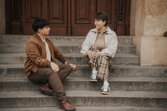 Couple chatting while seated on the museum steps during a couple photoshoot in Prague.