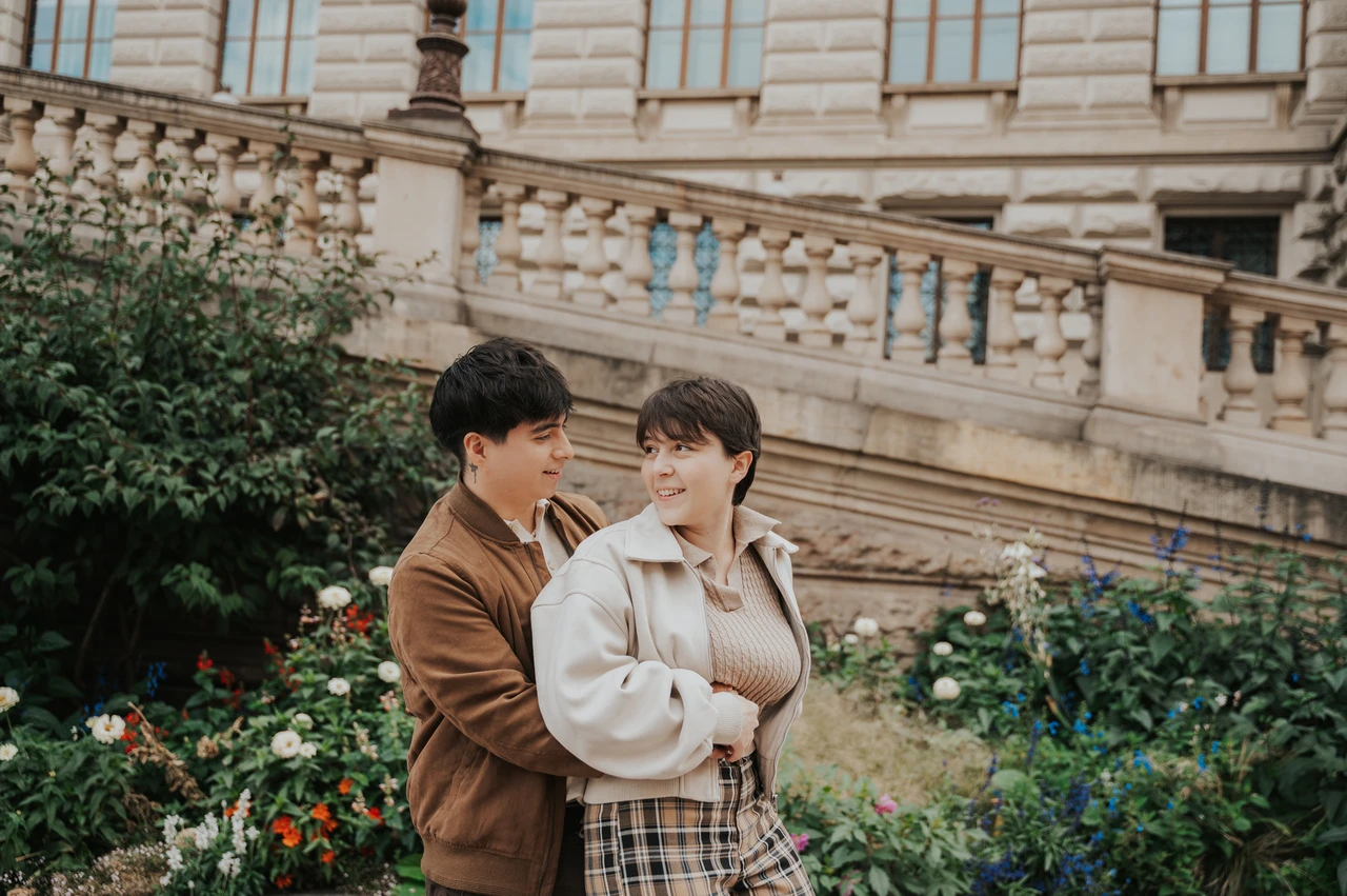 Prague couple photoshoot: couple embracing beside the flowers outside the museum. Couple embracing beside the flowers outside the museum during a couple photoshoot in Prague.
