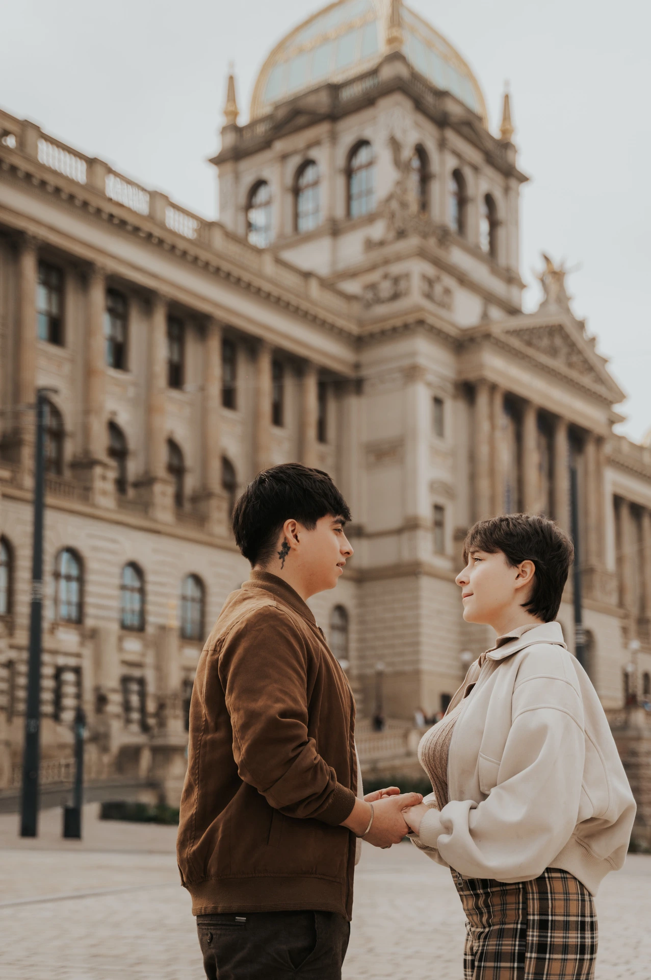 Couple facing each other on the museum forecourt during a couple photoshoot in Prague.