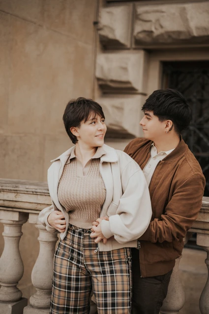 Prague couple photoshoot: couple looking at each other beside the museum wall. Couple looking at each other beside the museum wall during a couple photoshoot in Prague.
