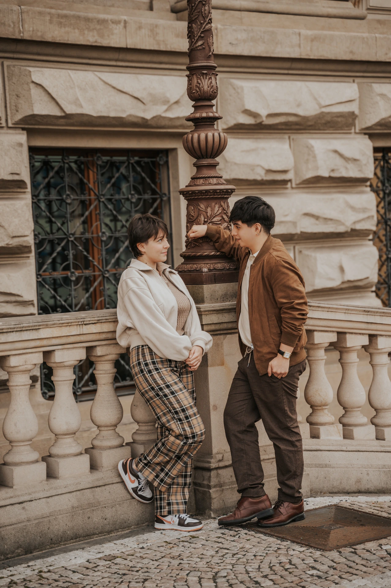 Couple smiling at one another beside the railing during a couple photoshoot in Prague.
