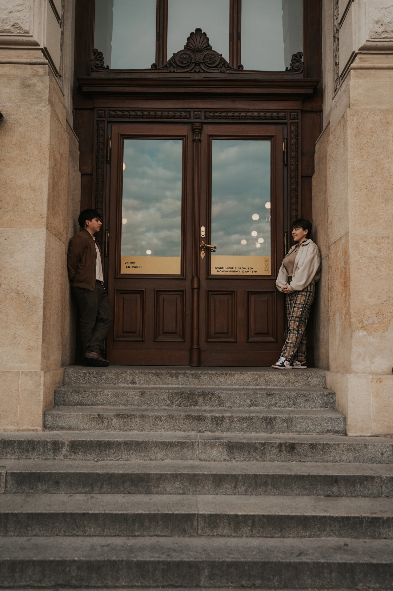 Couple standing either side of the museum entrance during a couple photoshoot in Prague.