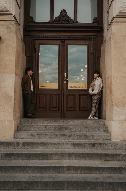 Prague couple photoshoot: couple standing either side of the museum entrance. Couple standing either side of the museum entrance during a couple photoshoot in Prague.