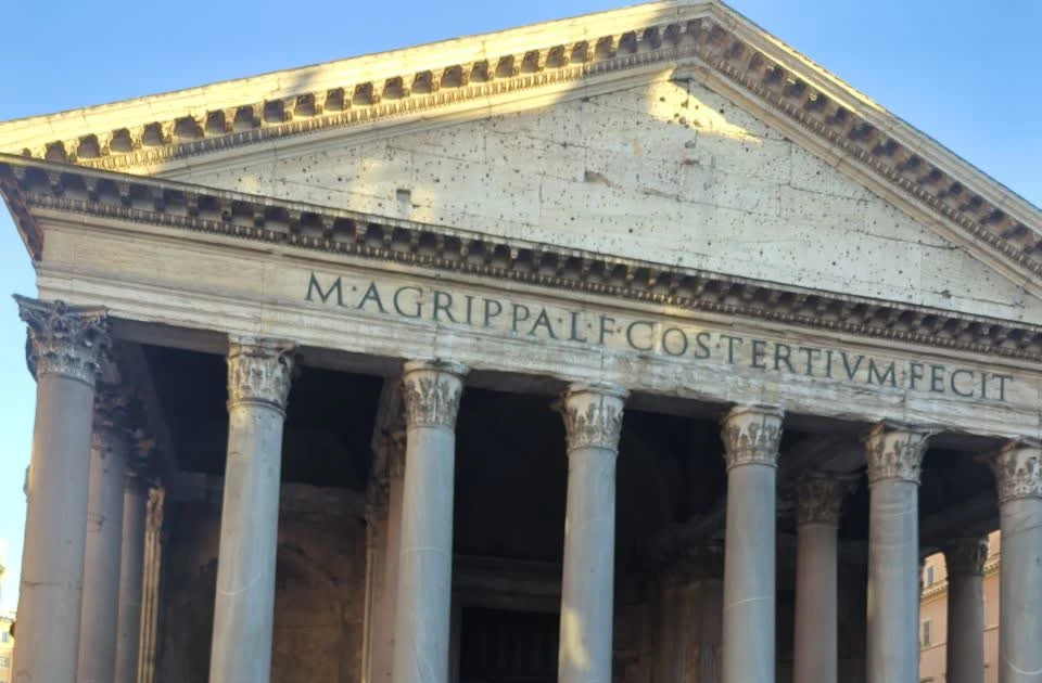 Rome Portrait Route - Pantheon Portico The Pantheon’s sunlit pediment, Latin inscription and tall stone columns fill a clear-sky view on a Rome portrait route.