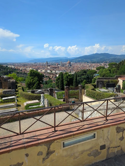Florence Skyline from San Miniato Florence stretches beyond a terrace railing and hillside greenery at San Miniato al Monte.