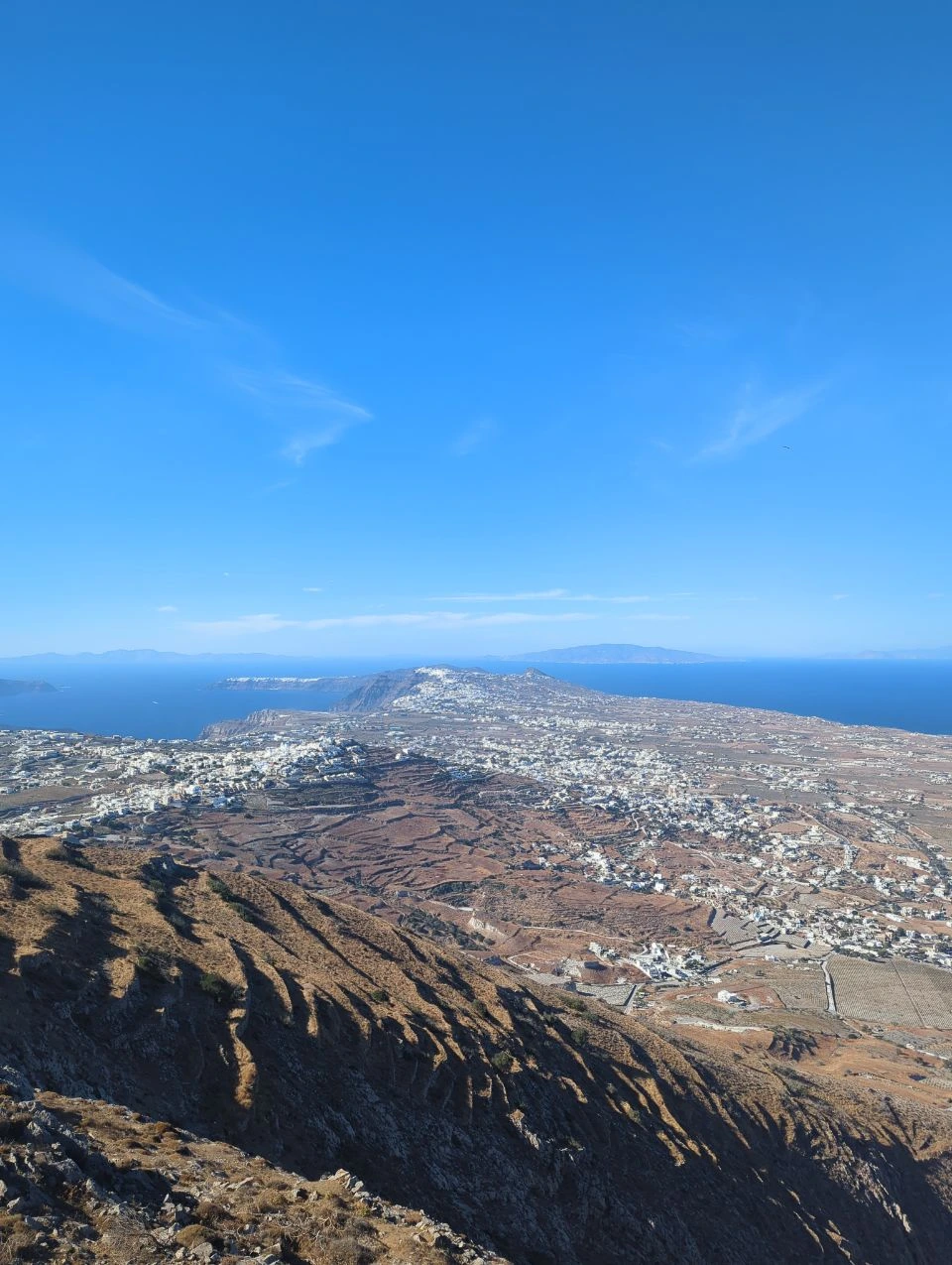 Broad view across Santorini's inland villages, caldera edge and sea from the high interior