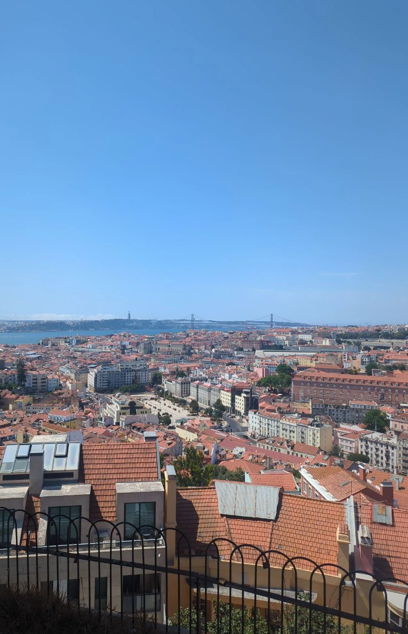 Lisbon’s rooftops, the Tagus, Cristo Rei and the red suspension bridge spread beneath a wide blue sky from Senhora do Monte.