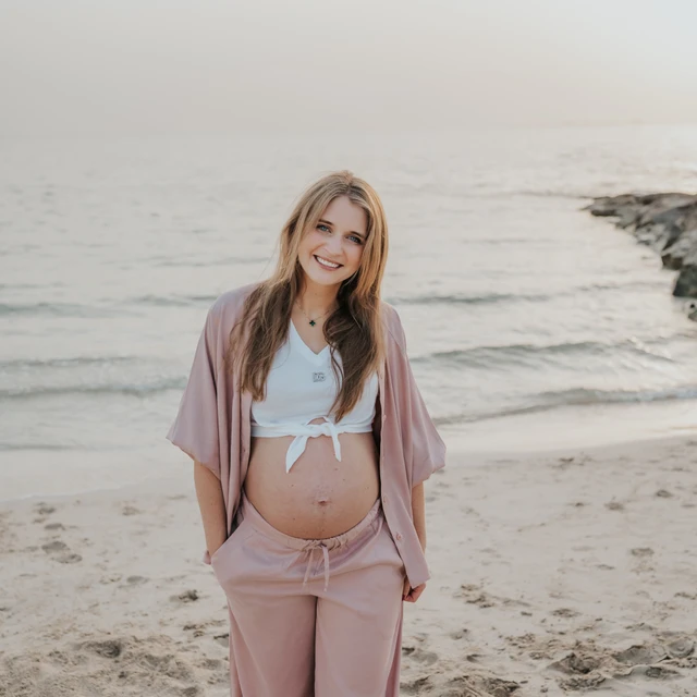 Sesión de Fotos de Embarazo en Dubai Una sesión de fotos de embarazo en Dubái, con la imagen centrada en la pareja y la barriga, y el mar de fondo.