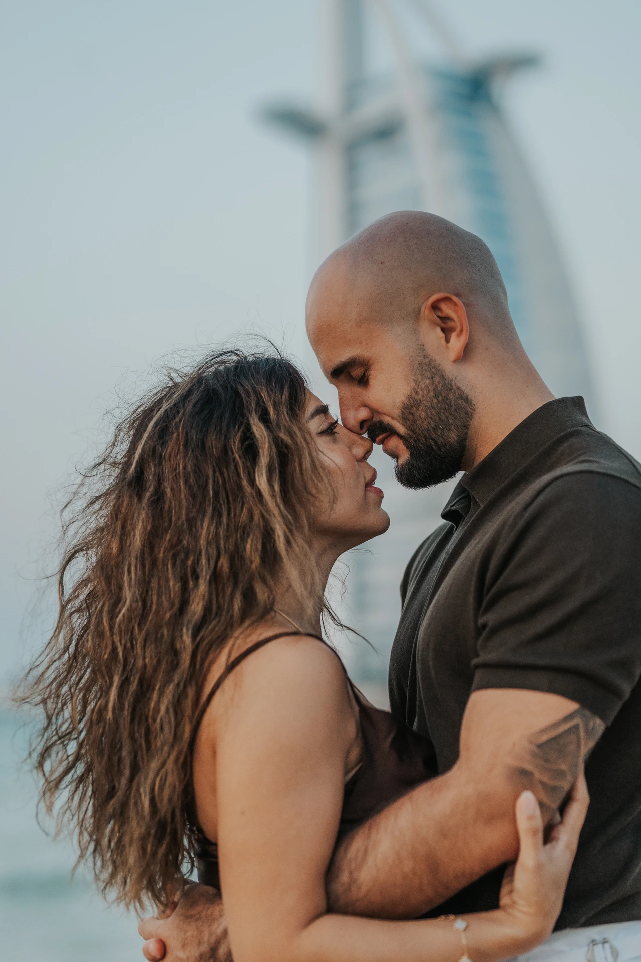 A couple shares an intimate close-up portrait after a proposal at Shimmers in Dubai, focusing on expressions and warm connection.