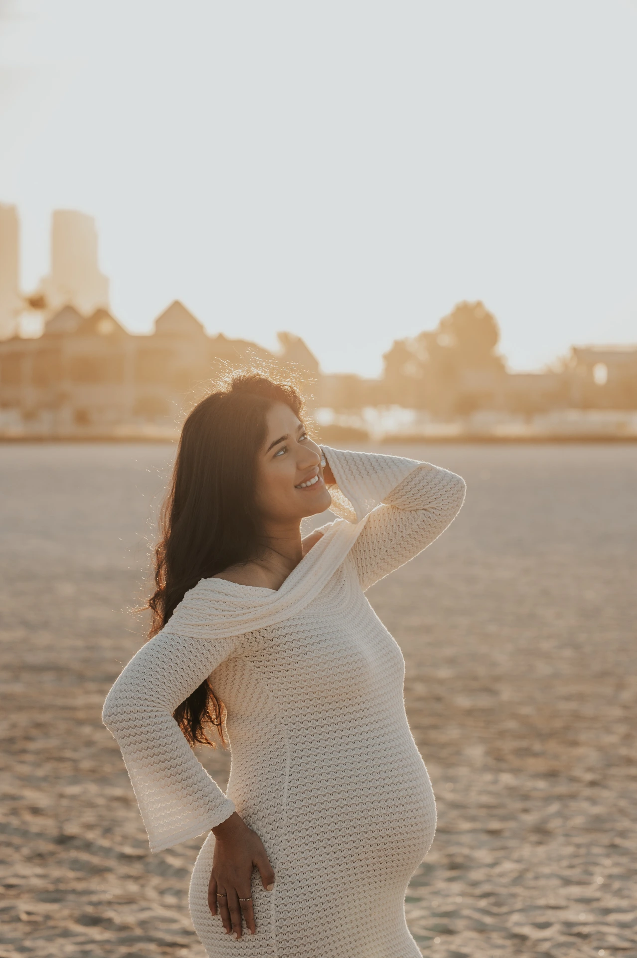 A pregnant woman poses outdoors near sunset during a Dubai maternity photoshoot, highlighting a calm natural look for the outdoor session style.