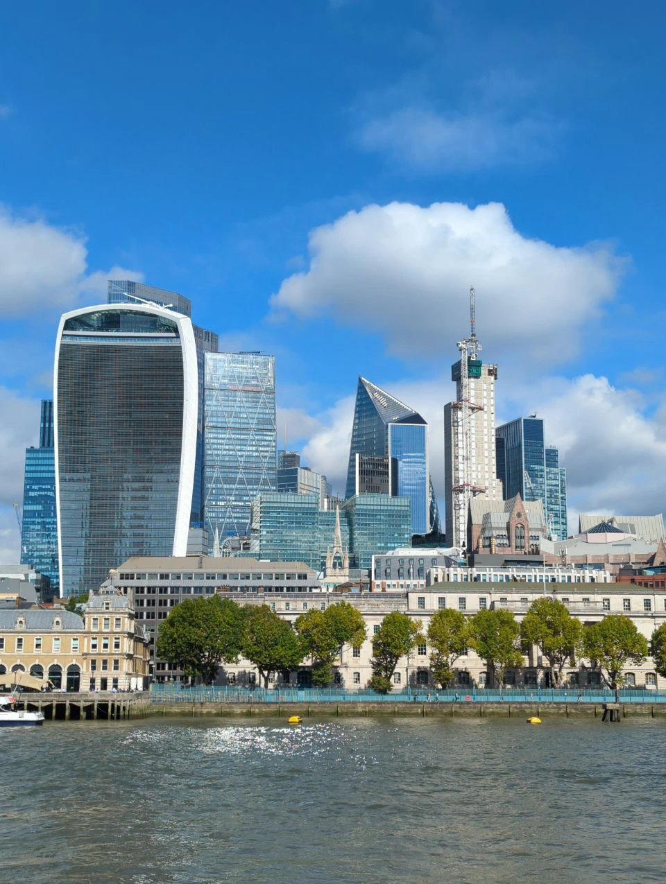 Daytime north-bank City skyline across the Thames from near London Bridge City Pier, with the Walkie Talkie building