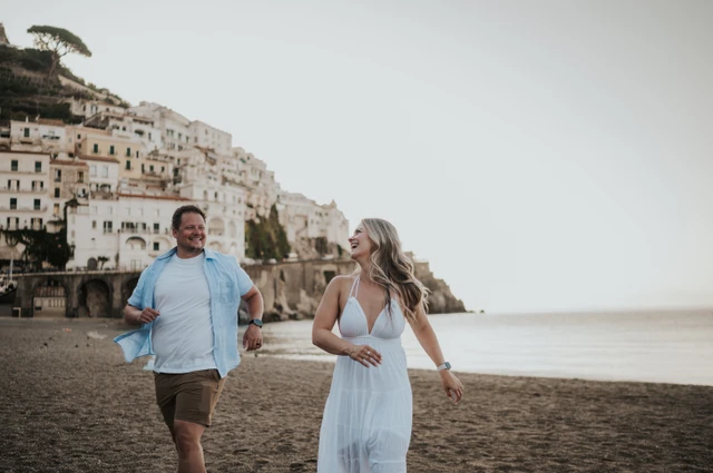 Couple smiling as they walk along Amalfi beach