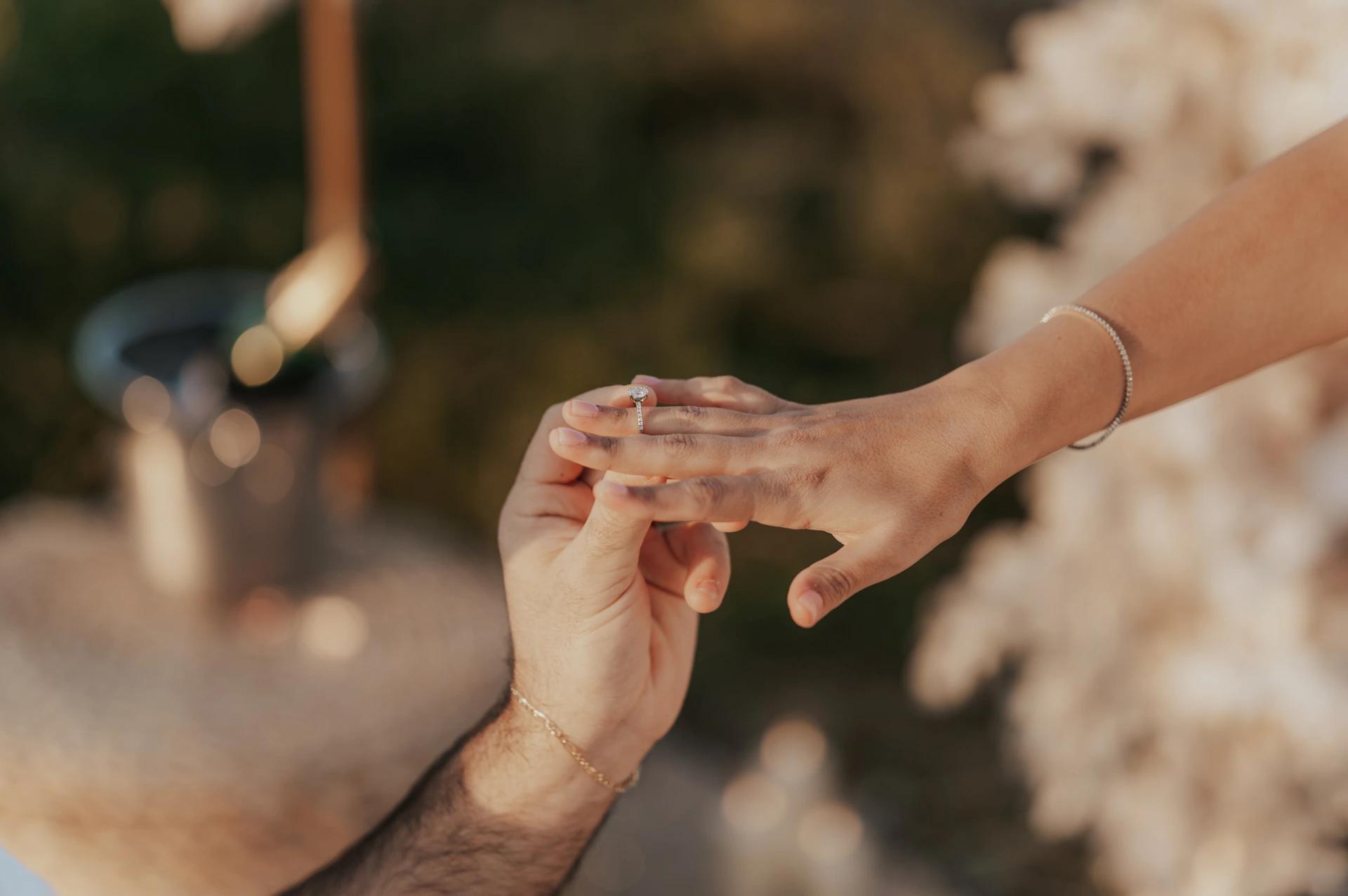 A man places an engagement ring on his partner’s finger in a close-up from a Dubai proposal photography session.