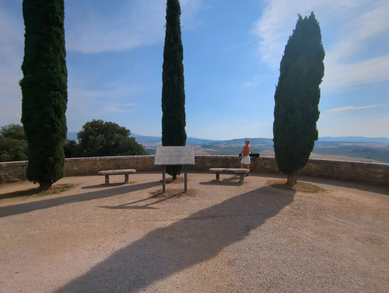 Val d’Orcia viewpoint framed by cypress trees and open Tuscan countryside