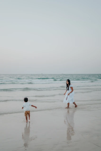 Vacation family photoshoot Dubai - beach moment A family walking together on a Dubai beach during a vacation photoshoot