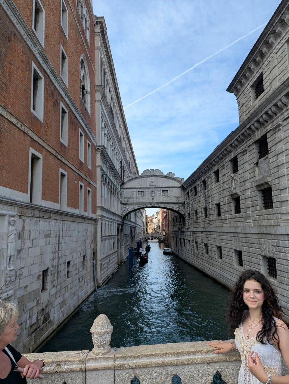 Person beside the canal with the Bridge of Sighs in the background