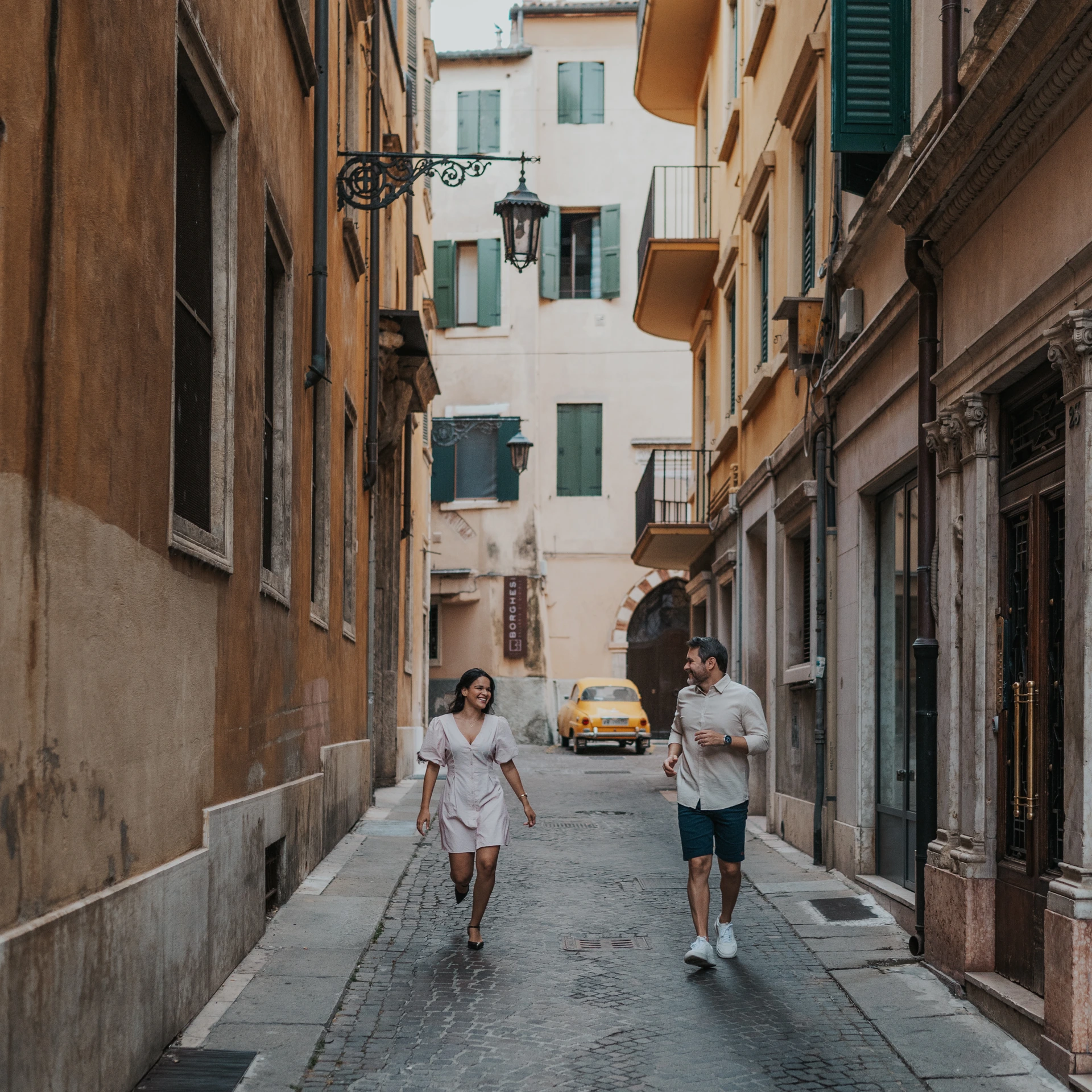 Couple walking along a narrow street in Verona