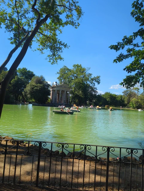Villa Borghese Lake and Temple Overhanging trees frame a green lake and a small columned temple in Villa Borghese, Rome.