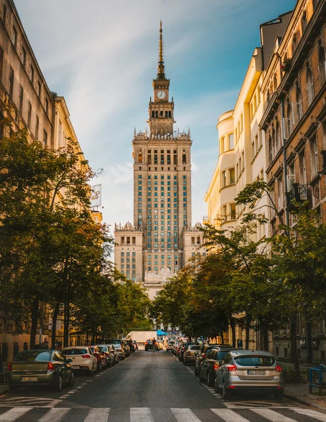 Warsaw buildings trough trees in the street