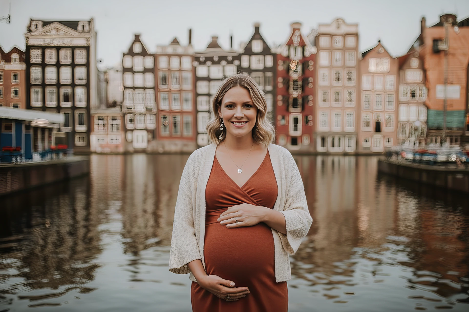 Een vrouw met haar buik in beeld bij de Damrak kade in Amsterdam tijdens haar zwangershapsshoot