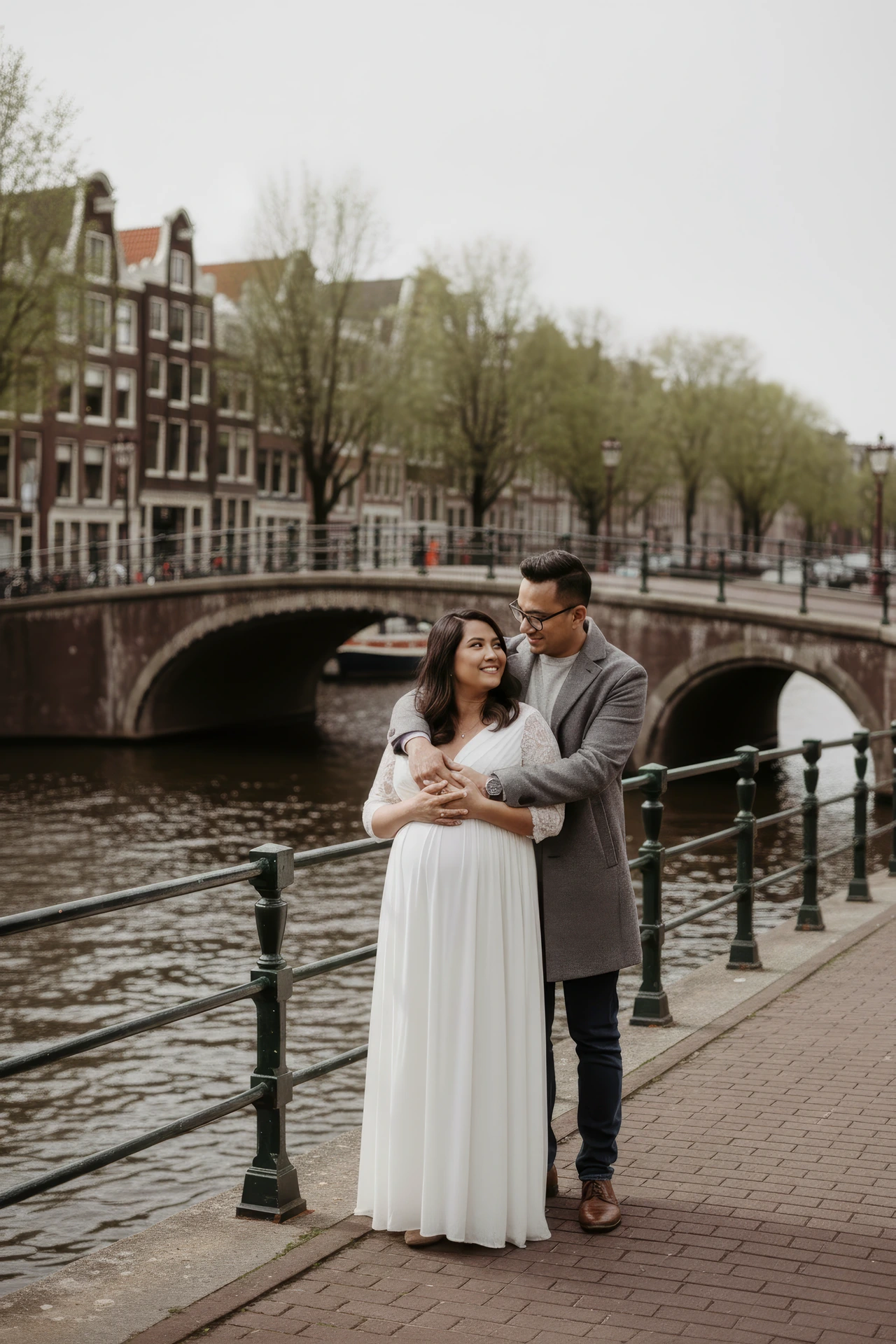 Zwangerschapsshoot in Amsterdam langs de grachten met brug op de achtergrond